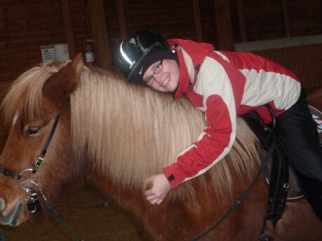 Melanie überglücklich auf einem Pferd